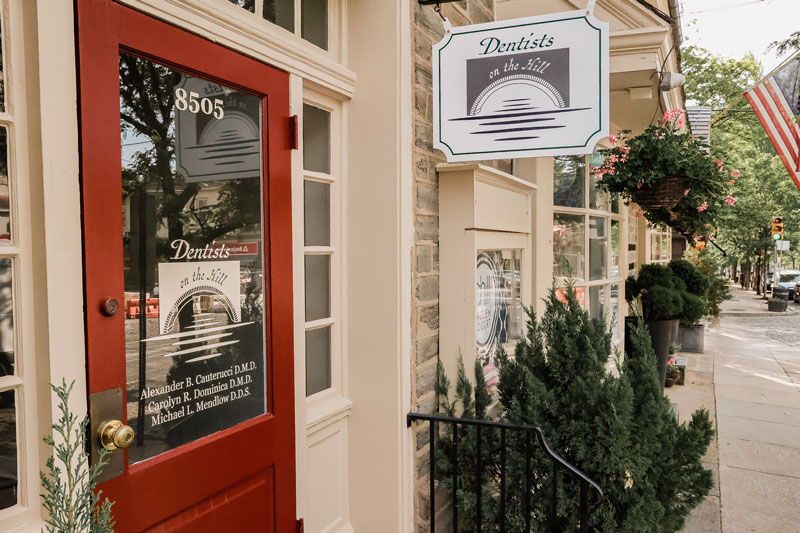 Street view of the dental off, Dentists of the Hill, showing their front door and office sign.